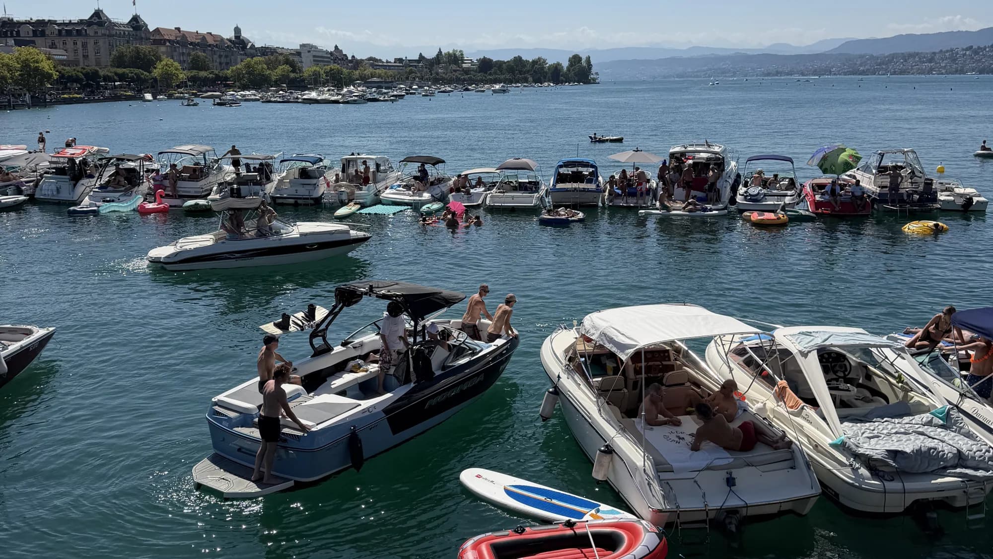 Boats and swimmers gathering on Lake Zurich